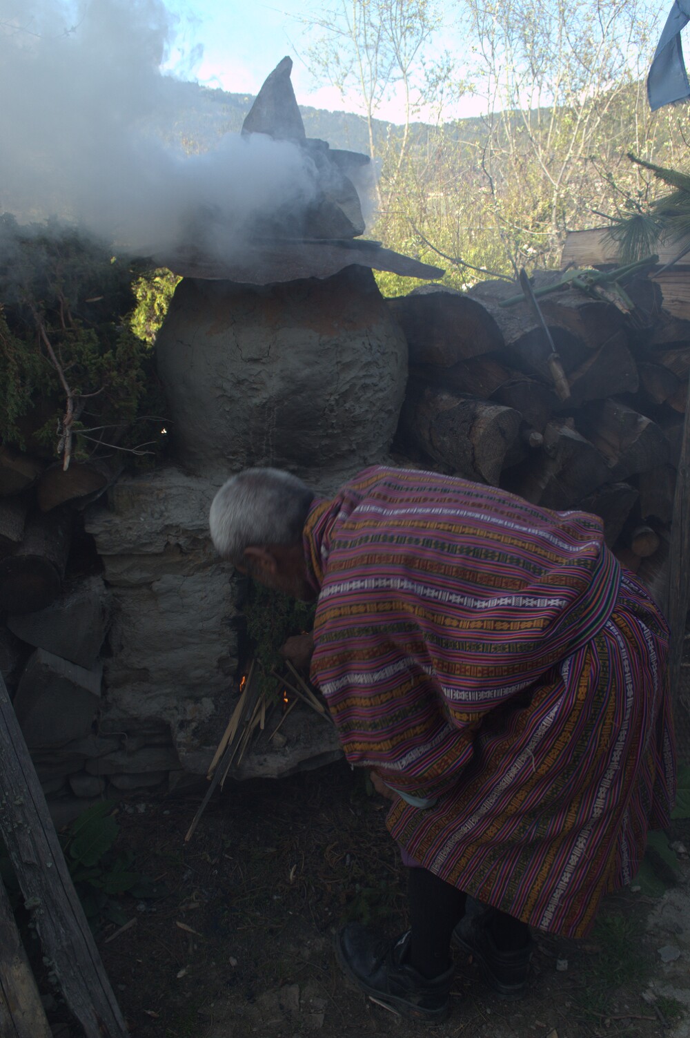 A local elder makes a smoke offering to welcome the Chakna Dorjé relic and procession.