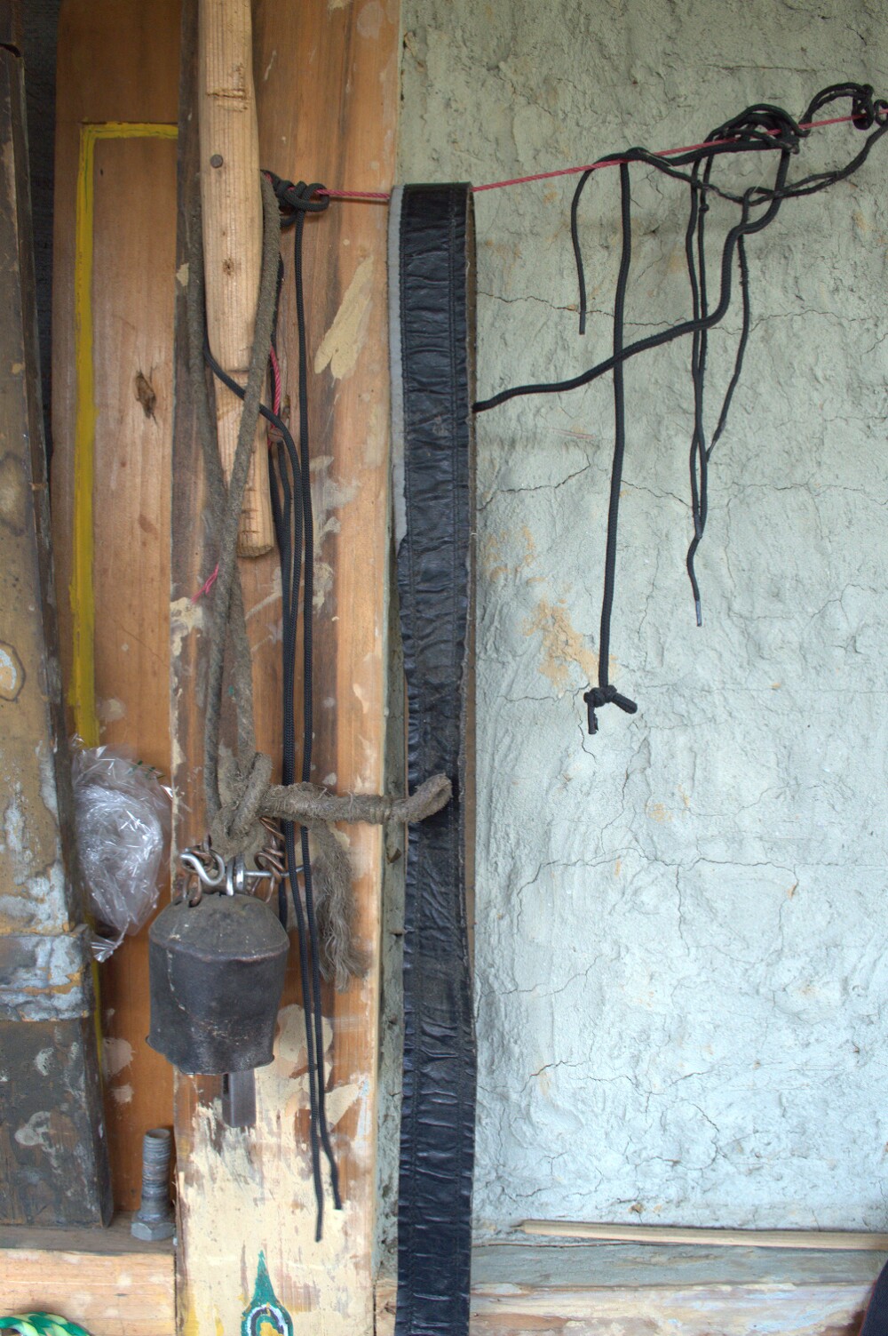 A wide mouthed traditional bell hangs outside a home.